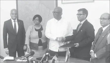  ??  ?? Minister of Finance, Winston Jordan (centre) shaking hands with Exim Bank of India’s Resident Representa­tive Sailesh Prasad, after signing the line of credit agreement. Also present are Guyana’s High Commission­er to India, Dr. David Pollard (left),...