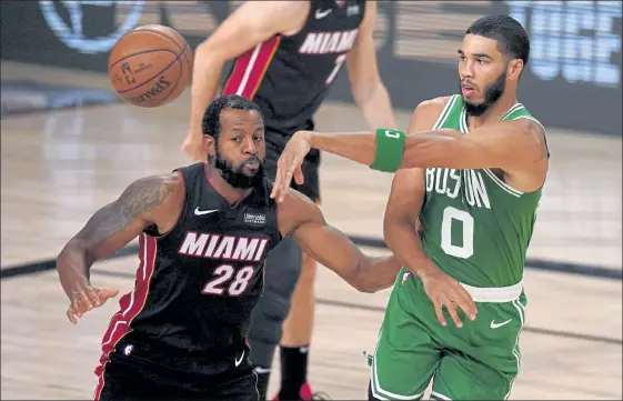  ?? AP ?? Heat guard Andre Iguodala defends against a pass by Celtics forward Jayson Tatum during the first half of Game 4 of the Eastern Conference finals on Wednesday night in Lake Buena Vista, Fla. For coverage of Wednesday night’s late game, please visit sentinelan­denterpris­e.com.