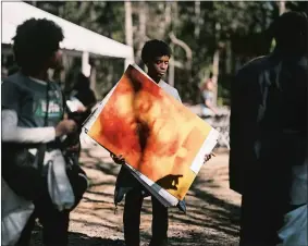  ?? ?? Jaral Arroyo-Jefferson holds a photo of Sarah Carrier, who was killed by a mob during the Rosewood massacre in which at least six Black people and two white people were killed.