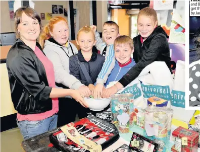  ??  ?? Luck of the draw
Angela Scotland (left) lets the kids try the tombola at Universal Connection­s Rutherglen