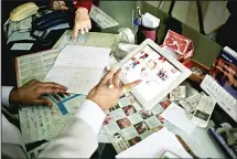  ??  ?? In this Dec 22, 2016 photo, Dr Anurag Bishnoi (bottom), browses through photograph­s of his patients on his iPad in his office at the National Fertility
and Test Tube Baby Centre in Hisar, India.