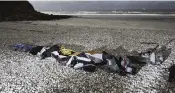  ?? RAFAEL YAGHOBZADE­H AP ?? Life jackets, sleeping bags and damaged inflatable small boat are pictured on the shore in northern France.