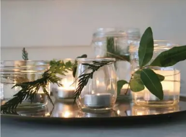  ?? DEBRA NORTON PHOTOS FOR THE TORONTO STAR ?? Glass jars and fresh greenery can be used to create a beautiful candle display.