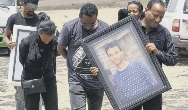  ?? PICTURE; GETTY ?? Members of the 28-year-old Captain Yared Getecho’s family visit the crash site of Ethiopian Airlines Flight 302 in Ejere, Ethiopia