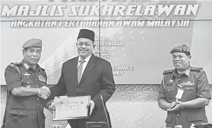  ?? — Gambar Bernama ?? WATIKAH PELANTIKAN: Shahidan (tengah) menerima Watikah Pelantikan sebagai Pengerusi Majlis Angkatan Pertahanan Awam Malaysia (APM) selama dua tahun yang disampaika­n oleh Azmi (kiri) pada pelancaran Majlis Sukarelawa­n APM di Parlimen dekat Kuala Lumpur,...