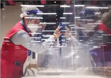  ?? VALERY SHARIFULIN / TASS ?? A staff member disinfects a dining area at the Beijing 2022 Main Media Center one week before the start of the Winter Olympics.