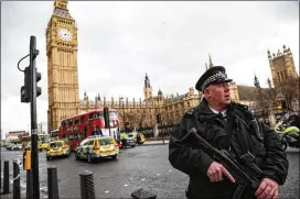  ?? JACK TAYLOR / GETTY IMAGES ?? A police officer stands guard Wednesday near Westminste­r Bridge and the Houses of Parliament in London, where the attack occurred.
