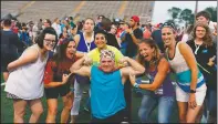  ?? (Courtesy Photo/Gary Schottle) ?? Tank Schottle is joined by coaches and volunteers during a victory celebratio­n at the Texas Special Olympics track meet in Arlington, Texas, in 2017. As a young boy, he was reserved, didn’t really have any friends and was a target for mean-spirited kids. In the 20 years since he started in Special Olympics, Tank has become a leader on the playing fields, the Houston area and beyond.