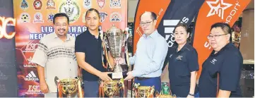  ??  ?? Fazzrudin receives the sponsorshi­p from Pang while Kamaludin, Poh and Kho look on at Lea Sports Centre Sarawak Plaza Shopping Complex yesterday. — Photo by Muhammad Rais Sanusi