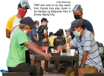  ??  ?? POND NEWS ASIA TWO men look on as they watch their friends they play chess in the Kartilya ng Katipunan Park in Ermita, Manila City.