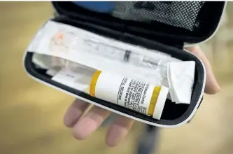  ?? THE CANADIAN PRESS FILES ?? A B.C. woman holds a naloxone kit in Vancouver on Nov. 13.