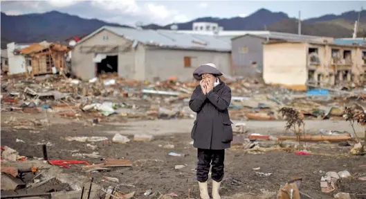  ?? REUTERS/CARLOS BARRIA ?? Japón, marzo de 2011. Una mujer se quiebra ante la imagen de su casa destrozada por un tsunami en la ciudad japonesa de Kessenuma.