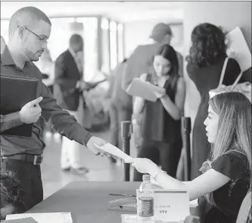  ?? Lynne Sladky Associated Press ?? A MAN submits a job applicatio­n at a January fair. Data released Friday show that the jobless rates for blacks and Latinos in April were at their lowest since the Labor Department began tracking the figures in the 1970s.