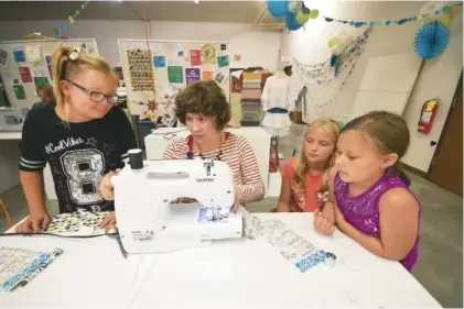  ?? STAFF PHOTOS BY TIM BARBER ?? Instructor Megan Emery, second from left, explains techniques during a recent Sew What class at the Chattanoog­a Public Library. The girls are, from left, Arissa Kenner, Emery, Emmalee Dittmar and Lailah Lockwood.