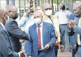  ?? Photo: Elmond Jiyane/gcis ?? Inspection: Cyril Ramaphosa (left) and Pravin Gordhan (not pictured) arrive at Transnet Durban Port and are received by Premier Sihle Zikalala (centre) and a number of other suits.