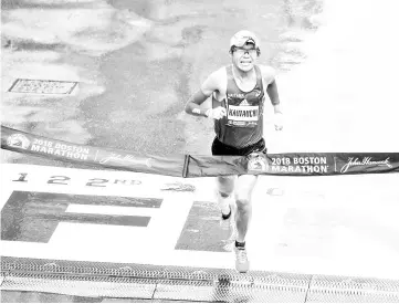  ?? - AFP photo ?? In this file photo taken on April 16, 2018 Yuki Kawauchi of Japan crosses the finish line as the winner of the 2018 and 122nd Boston Marathon in the elite men’s race with a time of 2:15:58 in Boston, Massachuse­tts. The Japanese high school clerk who...