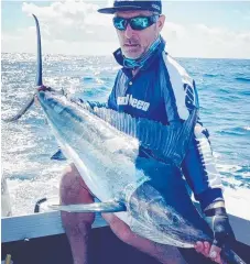  ??  ?? Jason Heller with one of the many small black marlin being caught.