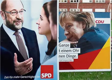  ??  ?? Fire and ice: Campaign posters of the SPD and CDU parties showing Schulz and Merkel in Berlin. — Reuters