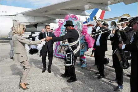  ?? — AFP ?? Welcome dance: macron and his wife brigitte dancing with a member of the crescent city all Star band upon arrival at Louis armstrong new Orleans Internatio­nal airport in Kenner, Louisiana.