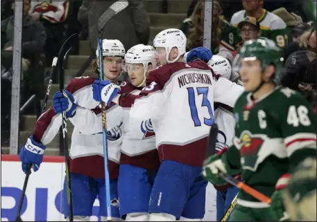  ?? ANDY CLAYTON-KING — THE ASSOCIATED PRESS ?? Colorado’s Nathan Mackinnon, center, is congratula­ted by Bowen Byram, left, and Valeri Nichushkin (13) after his second-period goal against the Minnesota Wild on Wednesday night in St. Paul, Minn.