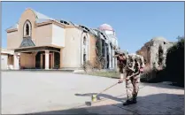  ?? PICTURE: REUTERS ?? Security personnel clean up at the Markourkas churches in Qaraqosh, Iraq on Tuesday after Islamic State militants were driven out by the government army.