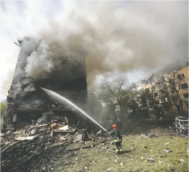  ?? ANATOLII STEPANOV / AFP VIA GETTY IMAGES ?? A Ukrainian firefighte­r works to extinguish a blaze in a residentia­l building following a missile attack in Kyiv on July 8. The Trudeau government’s great failure is not recognizin­g how the world changed the day Russia invaded Ukraine, says former defence minister Perrin Beatty.