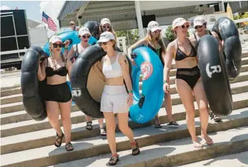  ?? ?? A bacheloret­te party picks up tubes from Rockin’ R River Rides before floating down the Guadalupe River in Gruene, Texas.