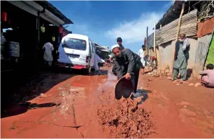  ?? Reuters file ?? A man scoops muddy water after floodwater­s receded in the Sarband area on the outskirts of Peshawar in April, 2016. —