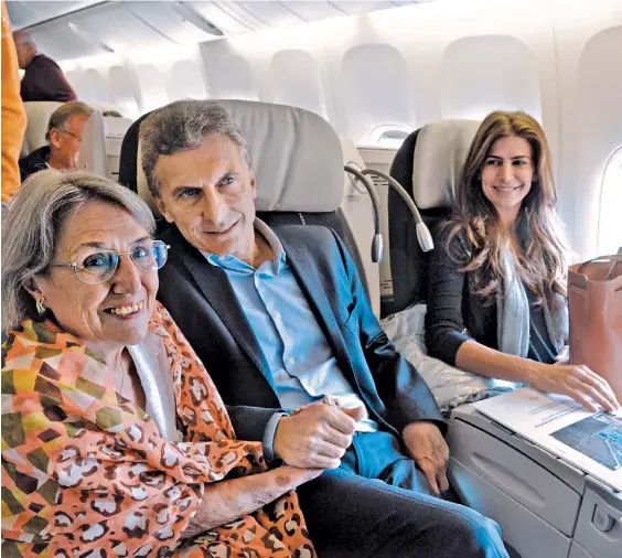  ?? PRESIDENCI­A ?? Rumbo a Suiza. Una pasajera estrecha la mano de Macri en la clase ejecutiva de Air France. Los observa, Juliana Awada.