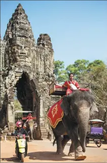  ?? PROVIDED TO CHINA DAILY ?? A mahout rides an Asian elephant at the gates of Bayon Temple at Angkor, Cambodia.