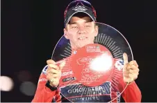  ?? — AFP photo ?? Evenepoel celebrates on the podium holding the trophy and wearing the overall leader’s red jersey after the 21st and last stage of the 2022 La Vuelta cycling tour of Spain.