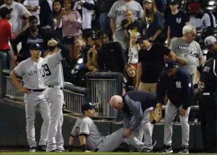  ?? PHOTOS BY NAM Y. HUH — ASSOCIATED PRESS ?? Yankees’ Dustin Fowler is checked by a team trainer after an injury in the first inning of Thursday night’s game against the White Sox in Chicago.