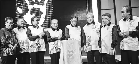  ??  ?? Abang Johari pressing his palm on a screen to symbolical­ly launch the CMEA logo witnessed by (from left) Dr Sim, Morshidi, SCCI president Datuk Abang Abdul Karim Abang Openg, Uggah, Awang Tengah, Peter and Len. — Photos by Chimon Upon