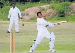  ??  ?? BIG HIT: Shacquille Thomas of the Nomzamo Wolves sends a ball to the boundary. Port Alfred High School second team captain Zimi Sonyakatsh­a looks on