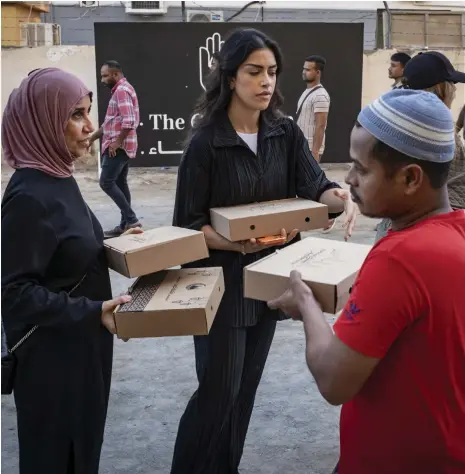  ?? Antonie Robertson / The National ?? Volunteers with The Giving Family hand out meals to workers at Al Quoz Industrial Area 1 in western Dubai