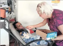  ?? PICTURE: DUNCAN GUY ?? EASTER TREAT: Sicelo, who was born physically and mentally challenged and became an orphan, receives an Easter egg from Adele Walters whose work at The White House home for helpless and handicappe­d people has given her life new meaning after losing her...