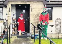  ??  ?? Spreading cheer Mrs Claus and piper Hamish Landale in Comrie