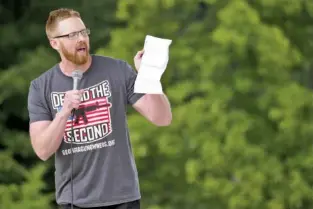  ??  ?? Georgia Gun Owners Executive Director Patrick Parsons holds a printed tweet by Reza Aslan at Saturday’s rally.