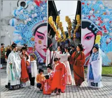  ?? SHI BUFA / FOR CHINA DAILY ?? Tourists wearing traditiona­l Chinese costumes take pictures at Poyang Ancient Street in Jinhua, Zhejiang province, on Dec 30.