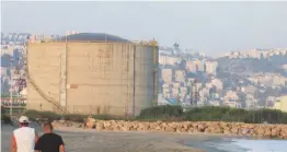  ?? (Max Yelinson/Maariv) ?? TWO MEN walk unimpeded toward a Haifa Chemicals 12,000-ton ammonia storage tank in this undated photo.
