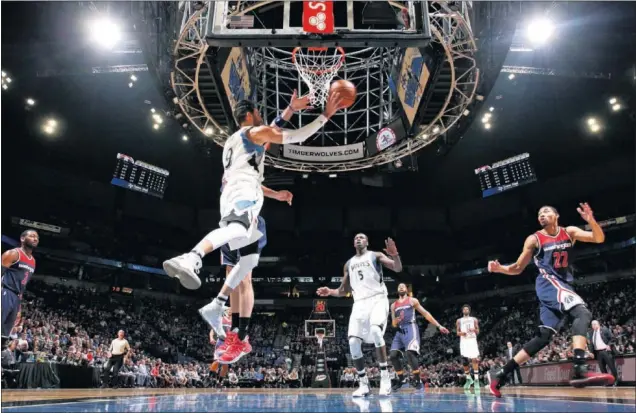  ??  ?? VISIÓN DE JUEGO. Ricky Rubio se prepara para pasar el balón a su compañero Gorgui Dieng durante el partido que enfrentó a los Timberwolv­es contra los Wizards.