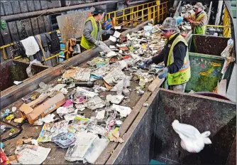  ?? SEAN D. ELLIOT/THE DAY ?? Workers at Willimanti­c Waste Paper Co. sort trash and other nonrecycla­ble materials Thursday out of a conveyor of single-stream recycled materials from throughout the region.