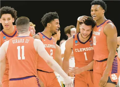  ?? BRANDON DILL/AP ?? Clemson guard Chase Hunter, second from right, is congratula­ted by, from left, teammates Joseph Girard III, Dillon Hunter and RJ Godfrey after a 3-point basket to end the first half in a second-round NCAA Tournament game against Baylor on Sunday.