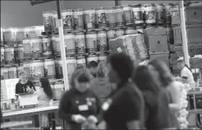  ?? TRIBUNE NEWS SERVICE ?? Over 200 volunteers sort and package food for local families at the Alameda County Community Food Bank in Oakland.