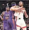  ?? ?? Houston’s Cam Whitmore (7) elbows the Suns’ Devin Booker during the second half of Thursday’s game at Footprint Center in Phoenix.