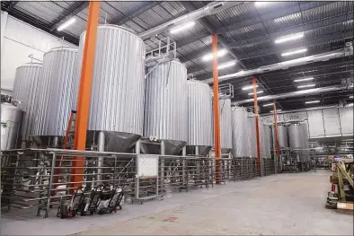  ?? Ned Gerard / Hearst Connecticu­t Media ?? Above, Athletic Brewing Co.’s new brewery in Milford on Friday. Below, Gov. Ned Lamont takes a sip of a non-alcoholic beer at the facility. Owners said the Milford plant is world’s largest non-alcoholic beer-making facility.