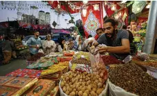  ?? AFP ?? An Egyptian trader sells dates and dried fruit at a market in the central Sayyida Zeinab district of Cairo last month