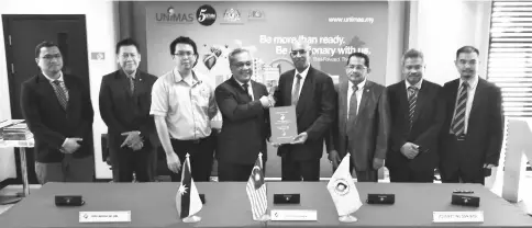  ??  ?? Mohamad Kadim (fourth left) shakes hands with Subramania­m after the MoA signing ceremony while Puah (right) and others look on.