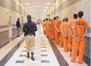  ?? DEAN HANSON/JOURNAL ?? Inmates are moved through a corridor at the Metropolit­an Detention Center.