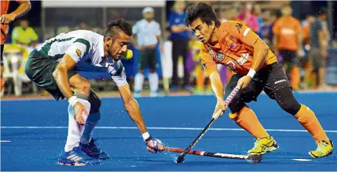  ??  ?? Out of my way: Malaysia’s Fitri Saari (right) vying for the ball with Pakistan’s Fareed Ahmed during the opening match of the Asian Champions Trophy at the Kuantan Hockey Stadium yesterday. — Bernama